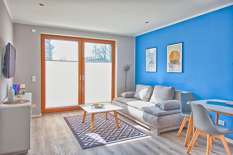 Gemütliches Wohnzimmer mit Holzmöbeln, blauem Sofa und stilvollem Interieur.