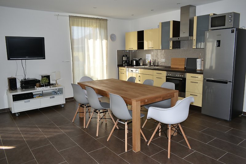 Moderne Küche mit Holzmöbeln, Küchengeräten und Fensterblick.