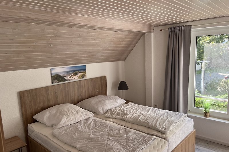 Gemütliches Schlafzimmer mit Holzmöbeln und bequemem Bett. Holz, Komfort, Bett.