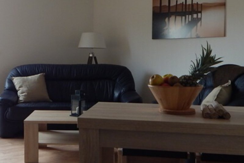 Gemütliches Wohnzimmer mit Holzmöbeln, Pflanzen und gemütlicher Beleuchtung.