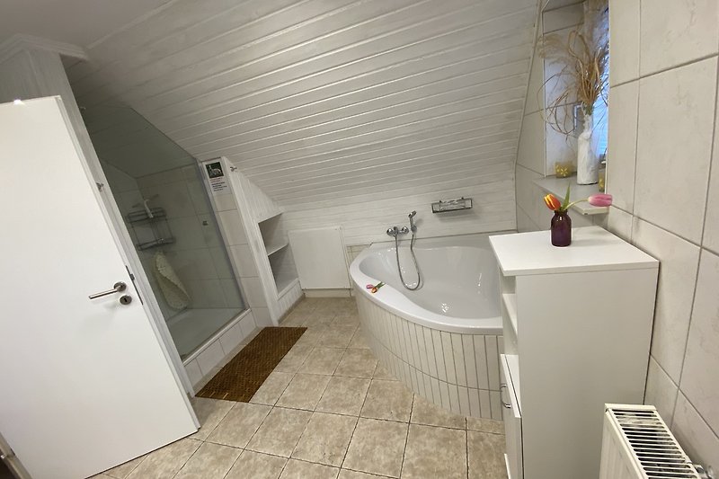 Modernes Badezimmer mit Dusche, Badewanne und 2 Waschbecken.