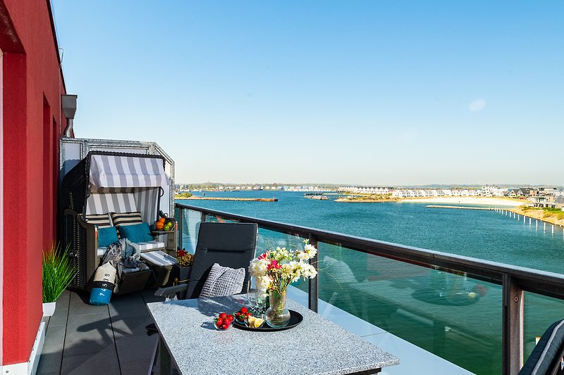 Balkon mit Blick auf die Marina in Olpenitz. Gemütliche Outdoor-Möbel. Strandkorb.