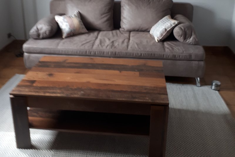 Un salon confortable avec un canapé en bois, des meubles en cuir et une décoration chaleureuse.