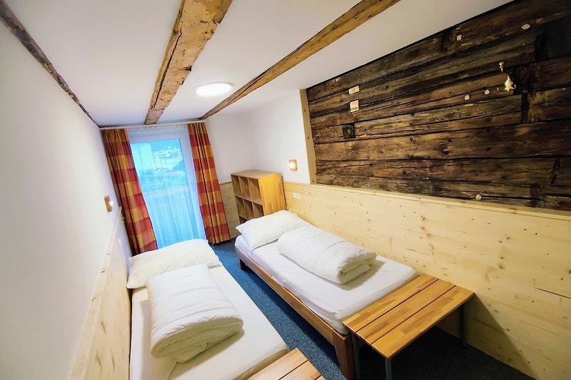 Gemütliches Zimmer mit Holzmöbeln und bequemem Bett.