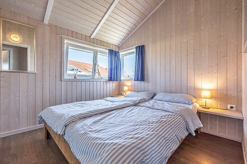 Komfortables Schlafzimmer mit Holzbett und gemütlicher Beleuchtung.