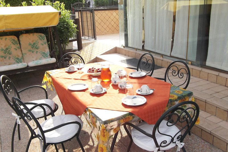 Elegante Terrasse mit Holztisch, Stühlen und Pflanzen. Erfrischend! ?️
