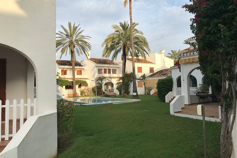Schönes Haus mit Garten und Palmen in einer ruhigen Anlage