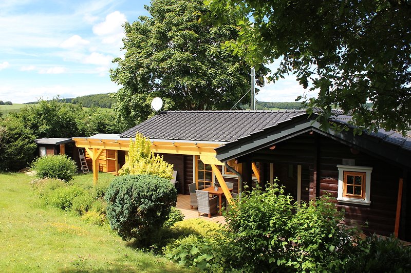 Blockhaus  mit  eingezäuntem Garten,  überdachter Terrasse