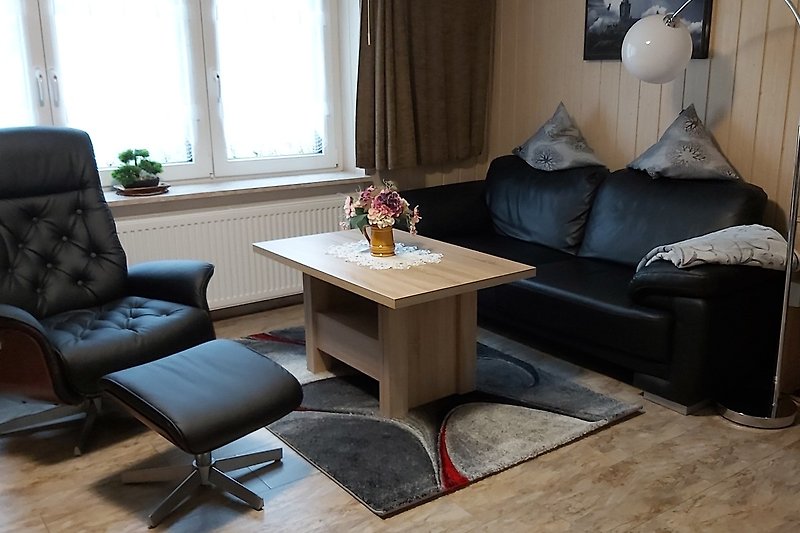 Stilvolles Wohnzimmer mit bequemer Couch, elegantem Tisch und gemütlicher Beleuchtung.