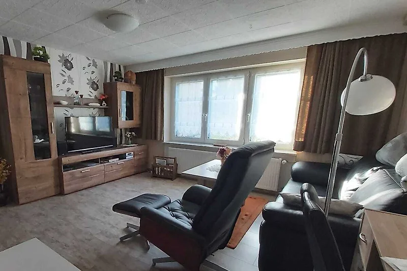 Wohnbereich mit Couch, Sessel, TV und stilvoller Einrichtung.