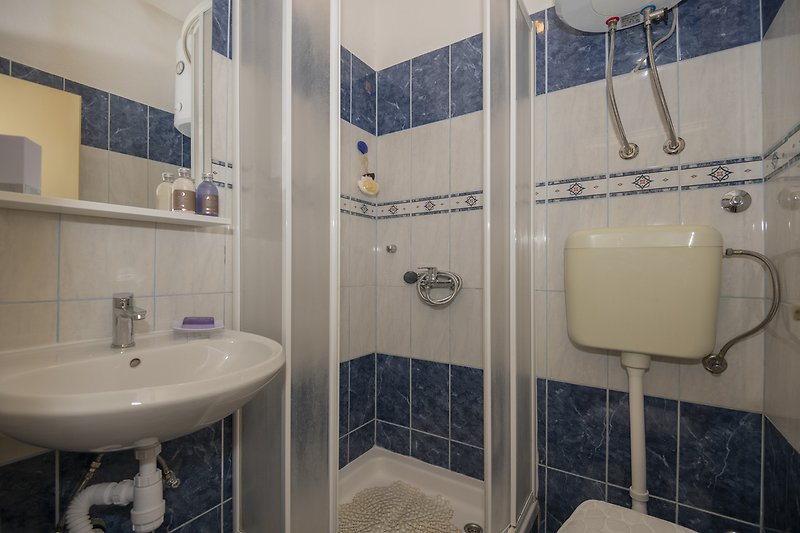 Moderan kupaonski prostor s ljubičastim detaljima i keramičkim umivaonikom.