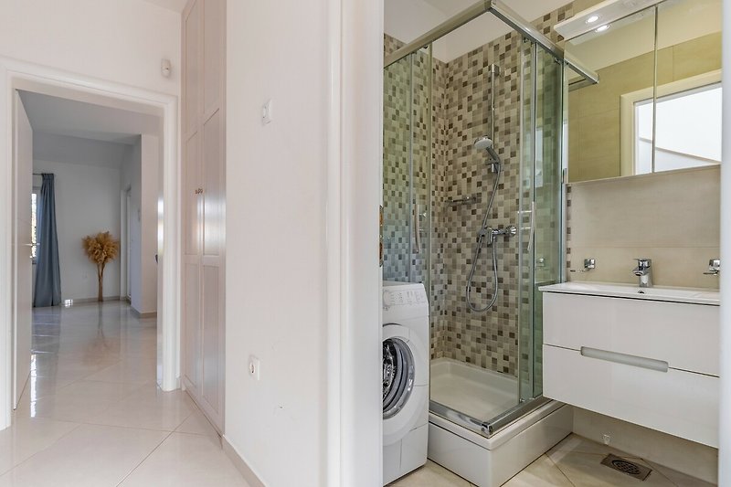 Gemütliches Badezimmer mit Spiegel, Waschbecken und Holzboden.