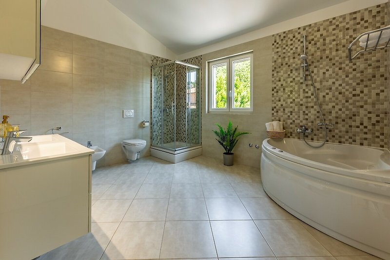 Einladendes Badezimmer mit Holzboden, Fliesen und Pflanzen.