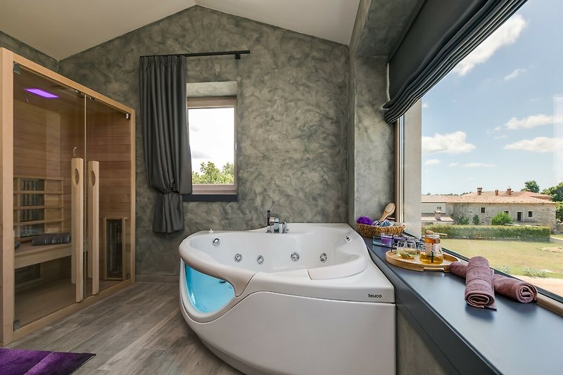 Schönes Badezimmer mit Jacuzzi, Fenster und Pflanzen. Entspannen Sie sich in luxuriöser Umgebung.