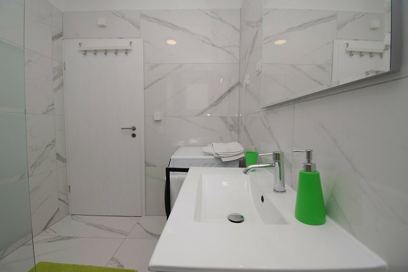 Modernes Badezimmer mit stilvollem Design, Glaswaschbecken und Spiegel.