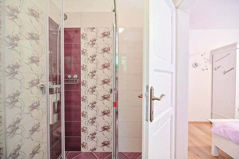 Moderne Badezimmer mit Glasdusche, Aluminiumtür und Fliesen.