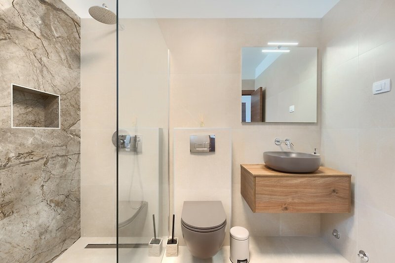 Ein stilvolles Badezimmer mit Spiegel, Waschbecken und modernen Armaturen.