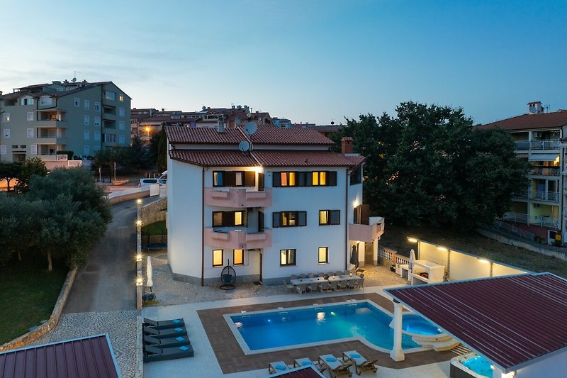 Luxusvilla mit Pool, Palmen und atemberaubendem Stadtblick.