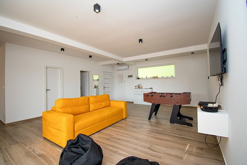 Gemütliches Wohnzimmer mit bequemer Couch und stilvollem Holzdesign.