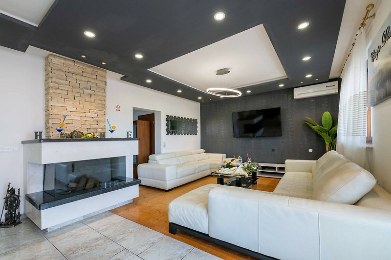 Wohnzimmer mit stilvollem Design, bequemer Couch und Pflanzen.