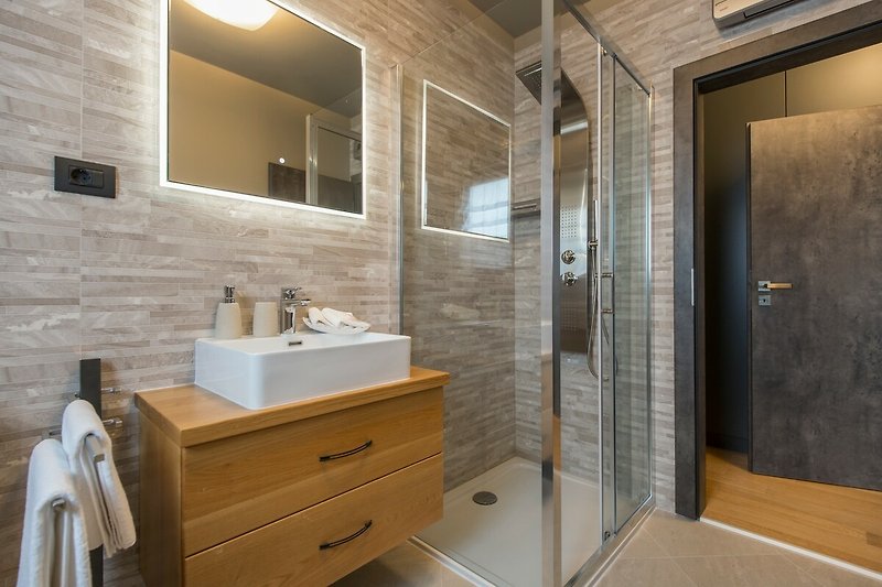 Gemütliches Badezimmer mit Spiegel, Wasserhahn und Badezimmerschrank.