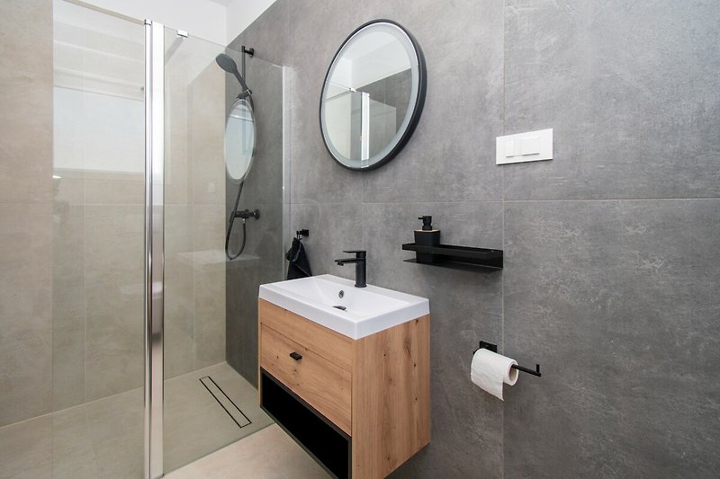 Modernes Badezimmer mit elegantem Spiegel und Armatur. Ideal zum Entspannen!