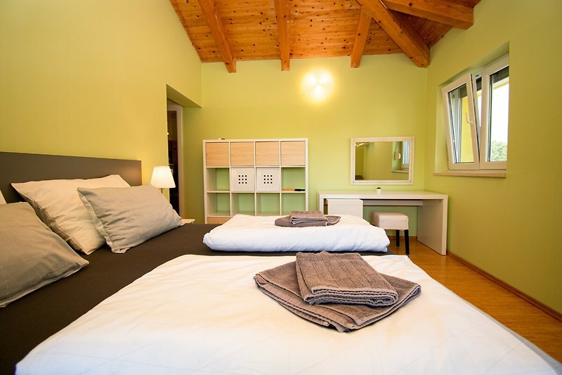 Gemütliches Schlafzimmer mit stilvollem Holzbett und gemütlichen Kissen.