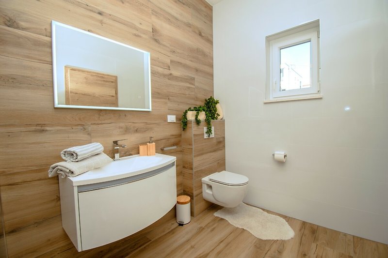 Badezimmer mit Spiegel, Waschbecken, Badewanne und Pflanze - modernes Design!