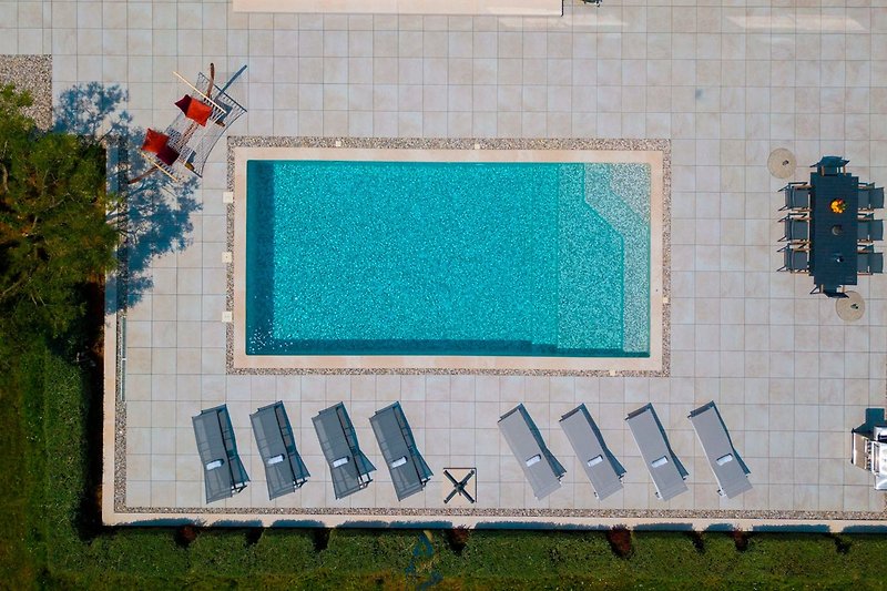 Schwimmbad mit blauem Wasser und moderner Architektur.