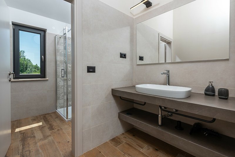 Ein stilvolles Badezimmer mit Spiegel, Wasserhahn und Waschbecken.
