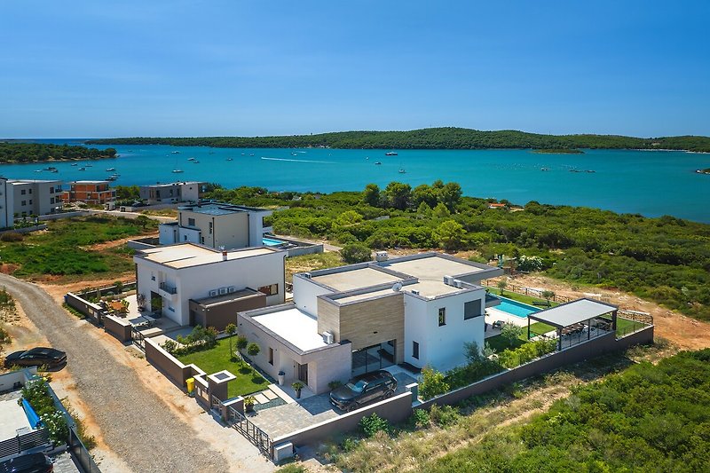 Schönes Haus mit Blick auf das azurblaue Meer und eine Küstenlandschaft.