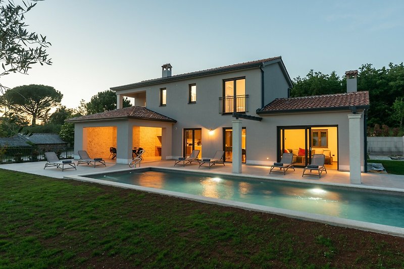 Ein Haus mit Pool und Blick auf das azurblaue Wasser.