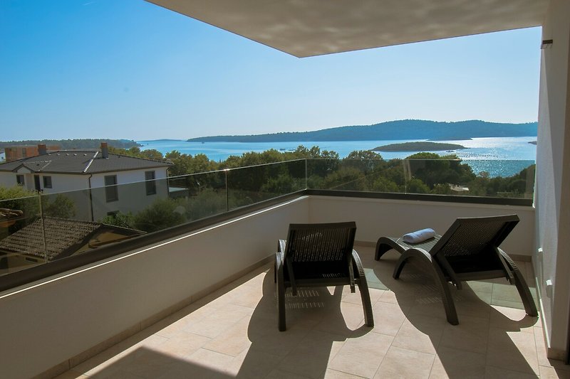 Balkon mit Meerblick und Stühlen - perfekt für Ihren Urlaub!