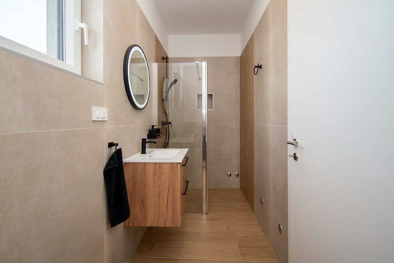 Modernes Badezimmer mit elegantem Spiegel, Armatur und Fenster - stilvoll entspannen!
