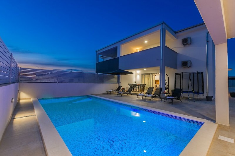 Schwimmbad und blauer Himmel mit Architektur und Fenstern.