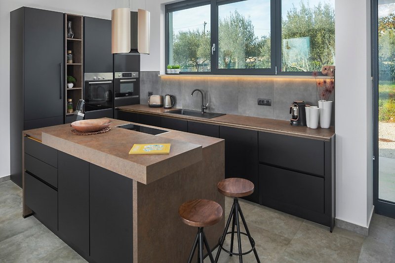 Moderne Küche mit Granit-Arbeitsplatte, Holzschränken und Fenster.
