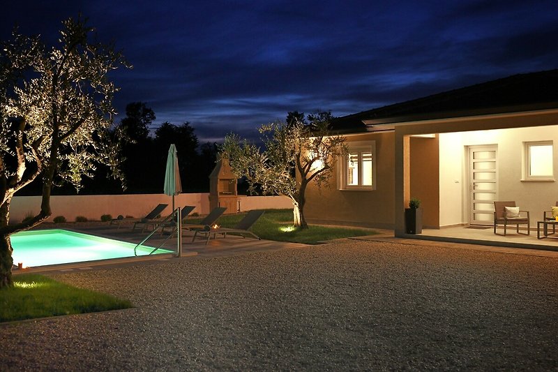 Schönes Haus mit gepflegtem Garten und abendlicher Atmosphäre.