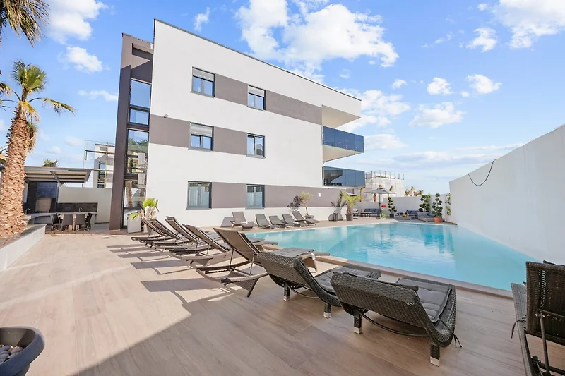 Penthouse mit Pool, Palmen, Outdoor-Möbeln und Boutique-Hotel-Flair.