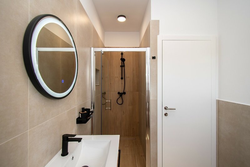 Modernes Badezimmer mit Glaswaschbecken, Armatur und Spiegel. Ideal für Entspannung.
