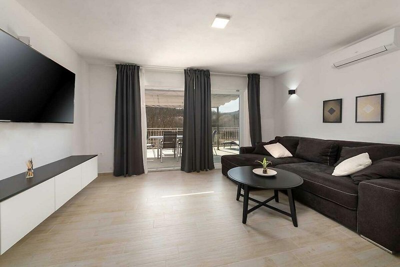 Wohnzimmer mit bequemer Couch, Holztisch, Lampe und Vorhängen - stilvoll eingerichtet!