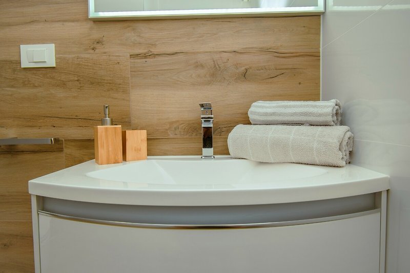 Badezimmer mit modernem Design, Keramik, Spiegel und Badewanne.