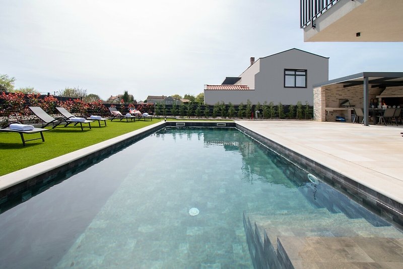 Luxuriöses Anwesen mit Pool, grüner Landschaft und modernem Design.