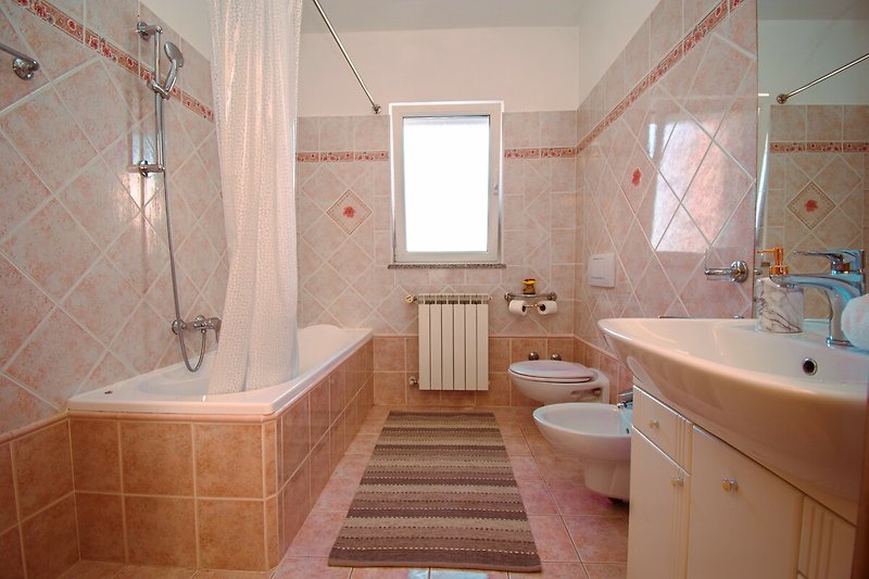 Gemütliches Badezimmer mit lila Vorhang, Holzmöbeln und stilvollem Spiegel.