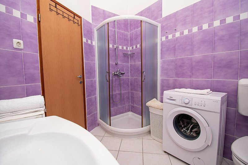 Moderne Badezimmer mit lila Akzenten, Dusche und Toilette.