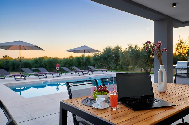 Pool, Sonnenliegen und Outdoor-Möbel für entspannte Stunden im Resort.