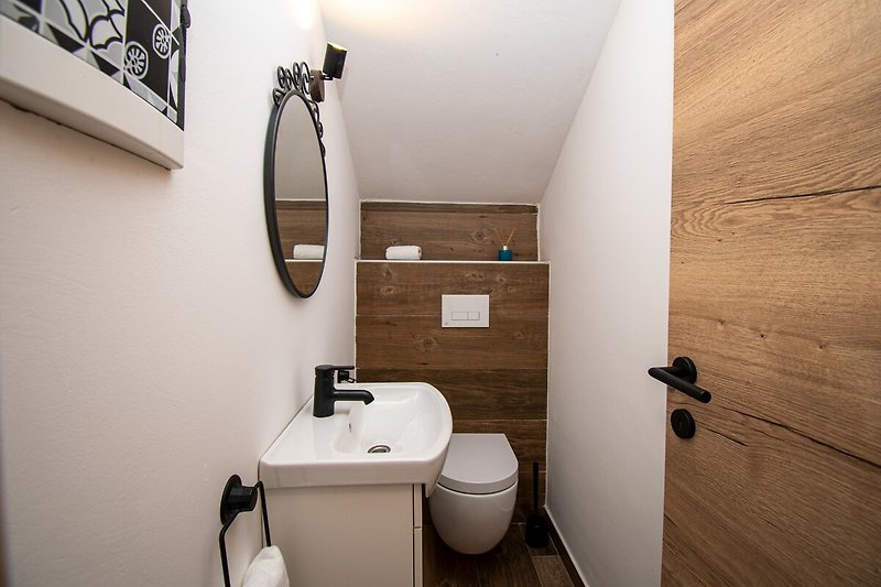 Modernes Badezimmer mit lila Akzenten und Holzelementen.