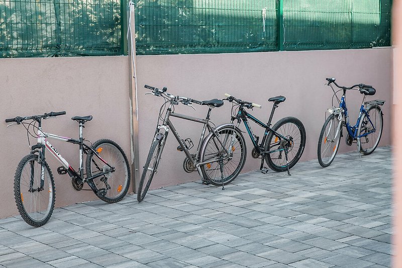 Fahrräder, Räder und Reifen vor einem Gebäude.