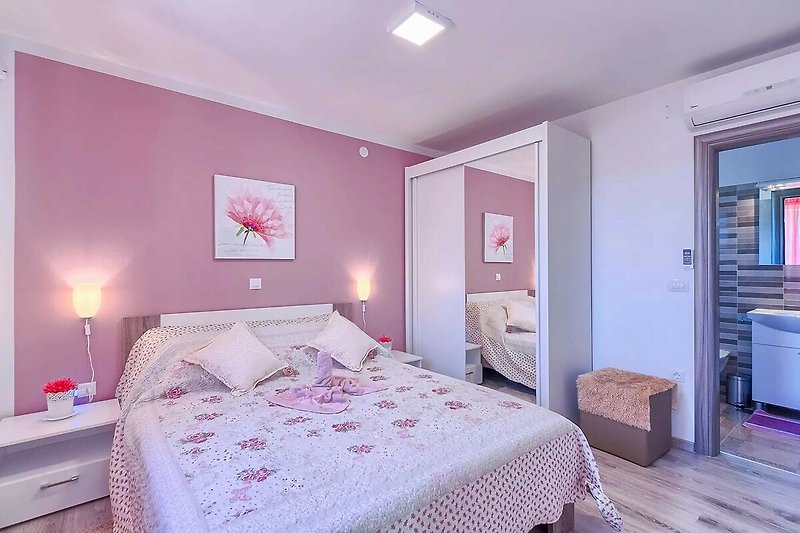 Genießen Sie den Komfort eines lila Schlafzimmers mit Holzmöbeln und gemütlichem Bett. Entspannen Sie und schlafen Sie gut!