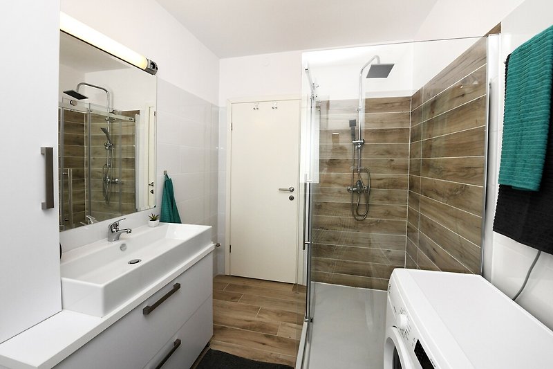 Badezimmer mit Spiegel, Waschbecken und Armatur