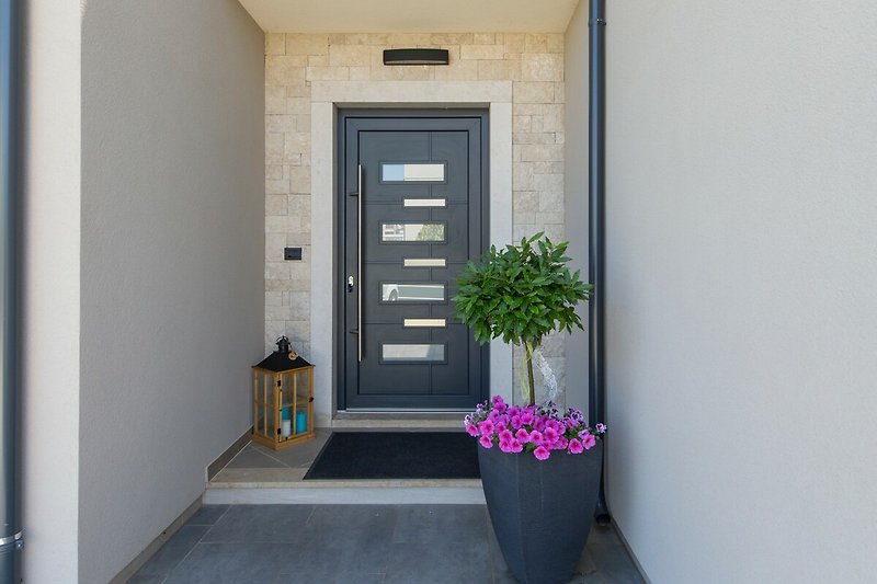 Einladendes Haus mit blumengeschmückter Fassade und Holztür.